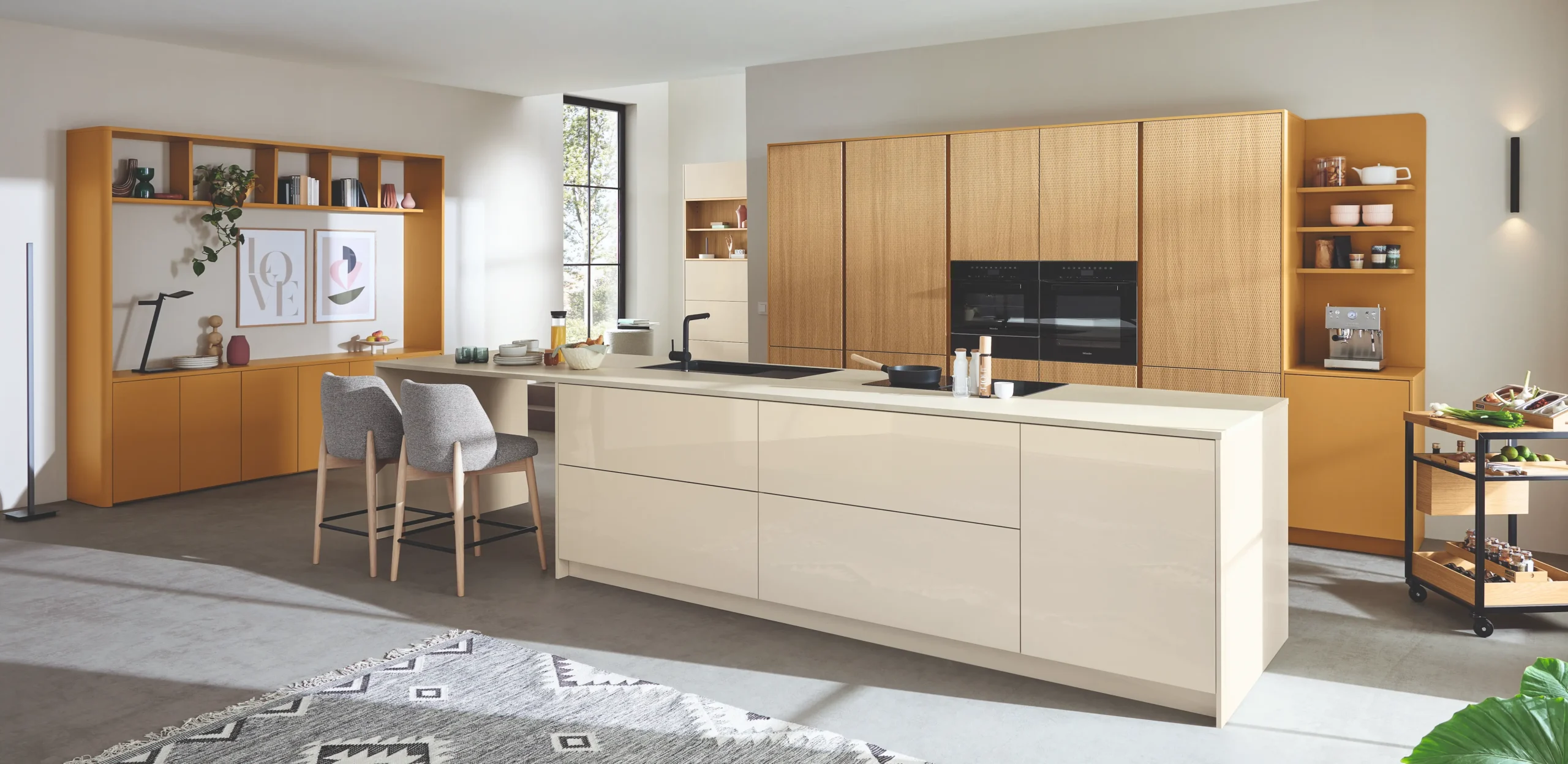 Hellen, moderne Küche mit weißer Kücheninsel mit Schublanden und hellen Holzschränken an der Wand